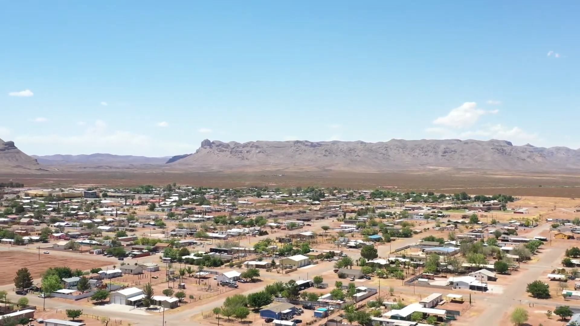 Aerial view of Van Horn, Texas, with residential streets and rugged desert mountains.